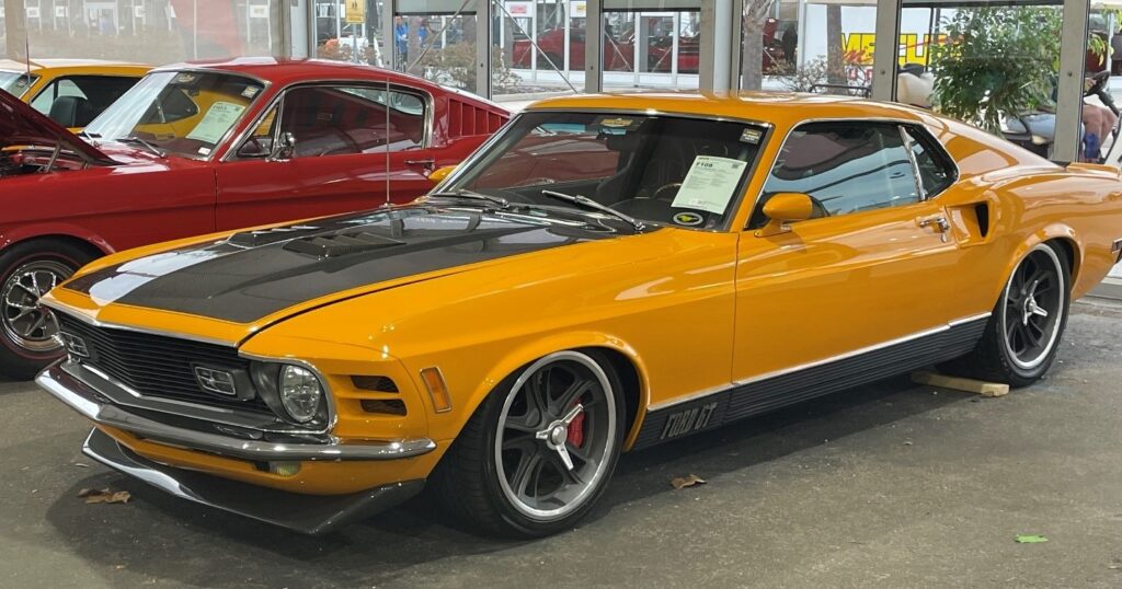 An orange and black Ford Mustang GT custom at an auction which is a favorite of the Baby Boomer Generation