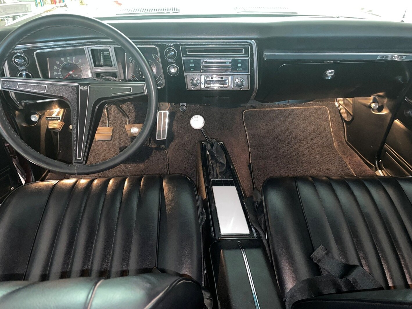 A black front seats and dashboard inside a 1968 Chevy Chevelle after being cleaned to remove interior odors