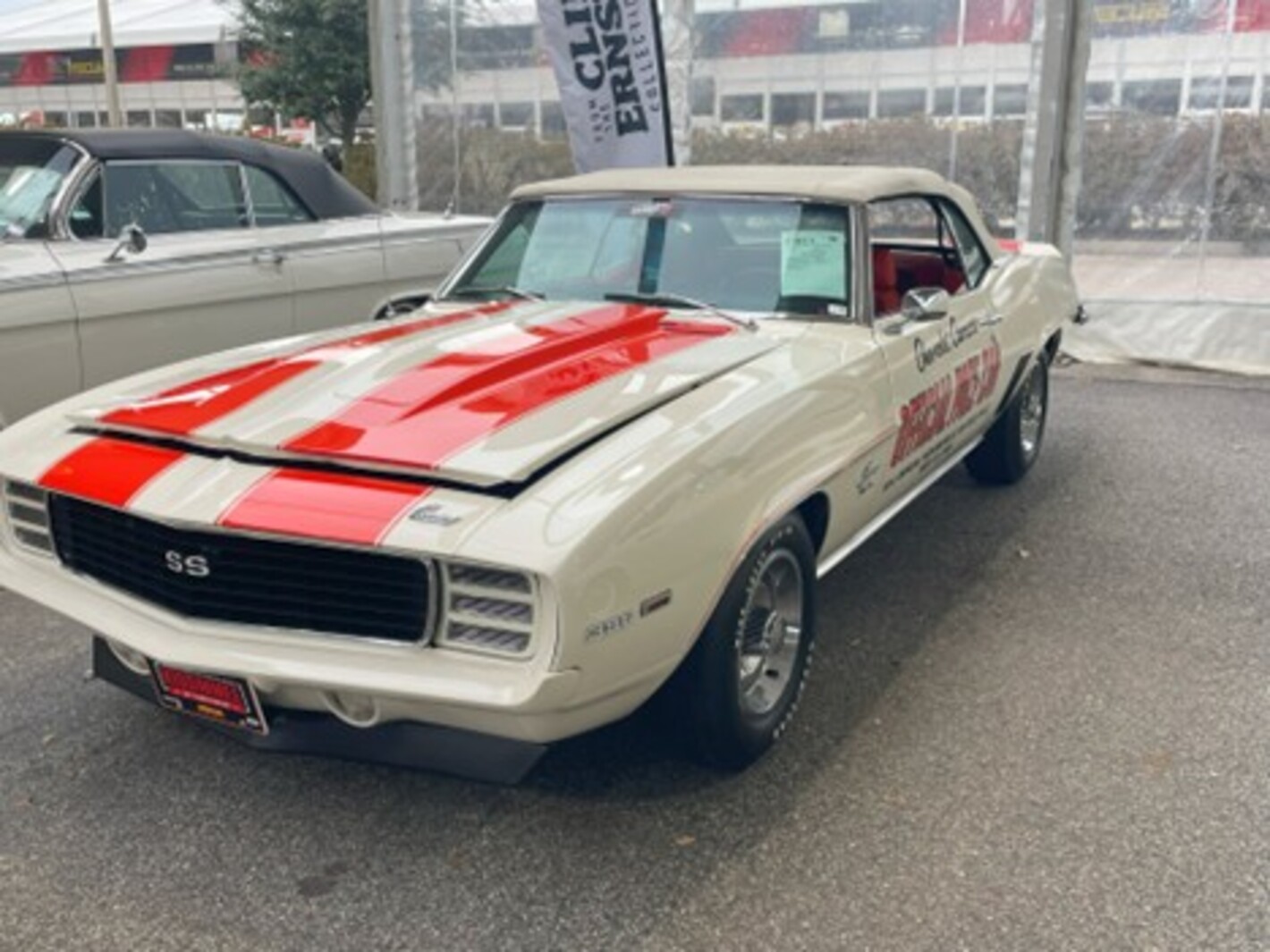 A white with orange stripe 1969 Chevy Camaro convertible with Official Pace Car written on the side at an auto auction is most likely not a waste of money to restore