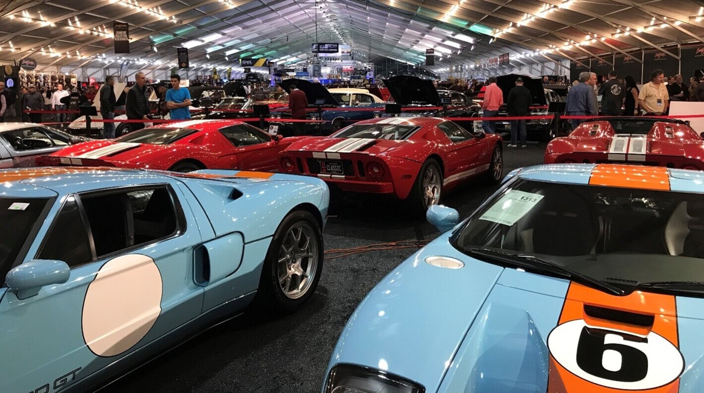 Blue and red Ford GT40s sitting inside a classic car auction as part of places to see vintage cars